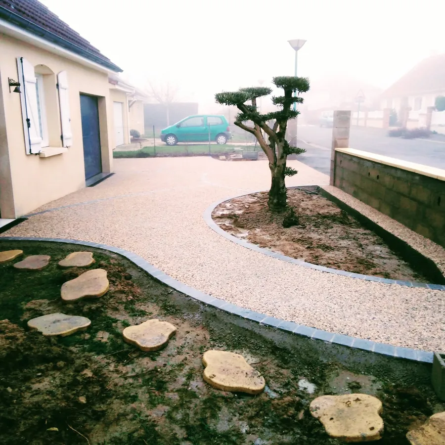 Allée en béton désactivé bordée, autour d'un massif