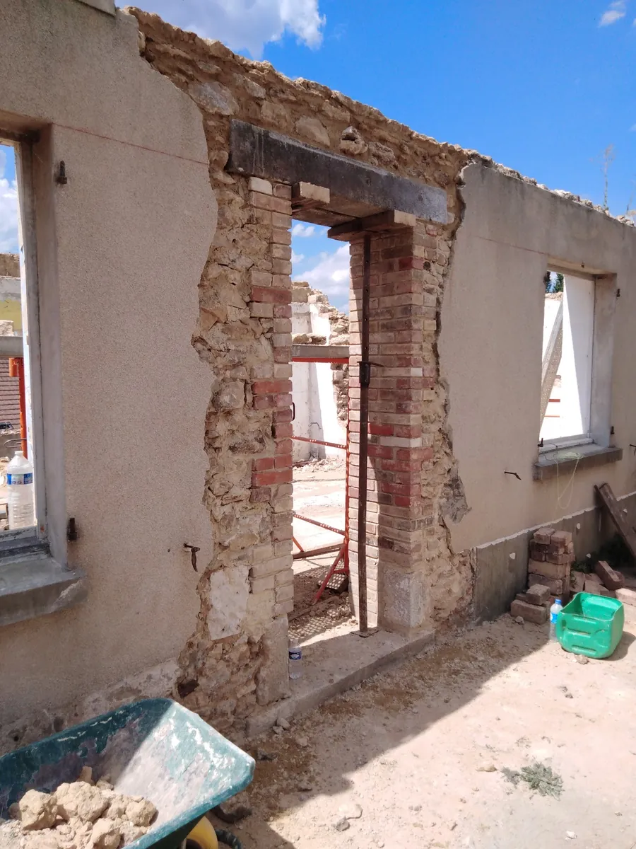 Ouverture créée dans un mur en pierre et brique, linteau en place